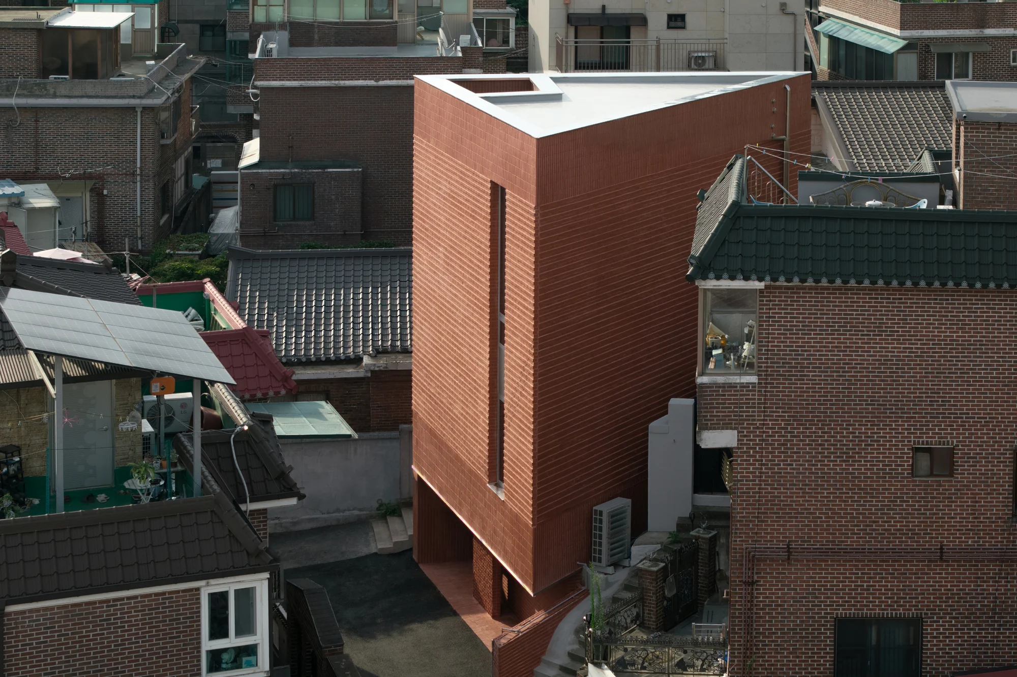 نمای داخلی ساختمان لایهای با متریال آجر و پله چوبی